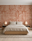 Bantu Lines Terracotta brush geometric wallpaper behind a low platform bed in a serene Japandi bedroom