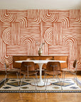 Bantu Lines Terracotta brush geometric wallpaper in a mid-century dining room with a teak sideboard and tulip table