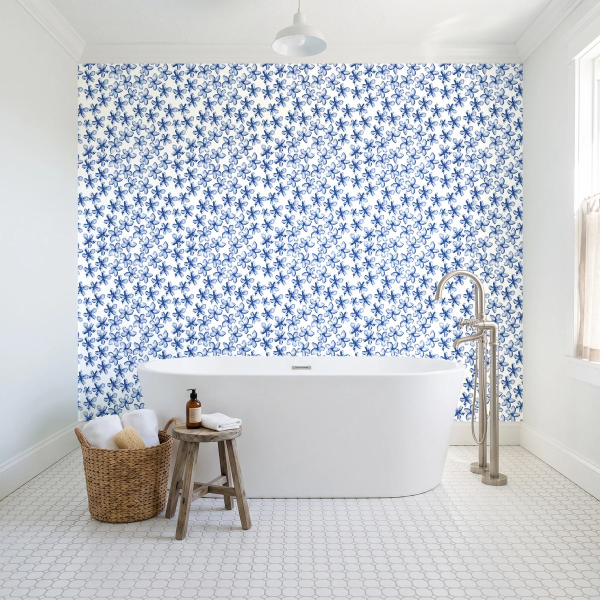 Blazing Petal Cobalt hibiscus floral wallpaper behind a freestanding tub in a bright coastal bathroom