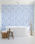 Blazing Petal Cobalt hibiscus floral wallpaper behind a freestanding tub in a bright coastal bathroom