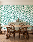 Blazing Petal Emerald hibiscus floral wallpaper in a farmhouse dining room with a sage sideboard and rustic trestle table