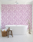 Blazing Petal Plum hibiscus floral wallpaper behind a freestanding tub in a bright coastal bathroom