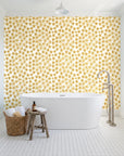 Blazing Petal Saffron hibiscus floral wallpaper behind a freestanding tub in a bright coastal bathroom