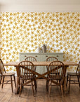 Blazing Petal Saffron hibiscus floral wallpaper in a farmhouse dining room with a sage sideboard and rustic trestle table