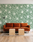 Blueprint Bloom Sage floral line wallpaper behind a rust velvet sofa in a bright coworking lounge