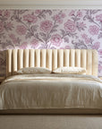 Blush Serenade Aubergine floral damask wallpaper behind a channel-tufted bed in a calm primary bedroom