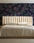 Blush Serenade Midnight floral damask wallpaper behind a channel-tufted bed in a calm primary bedroom