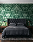 Blushed Whisper Emerald distressed damask wallpaper behind a tufted headboard in a dark, moody bedroom