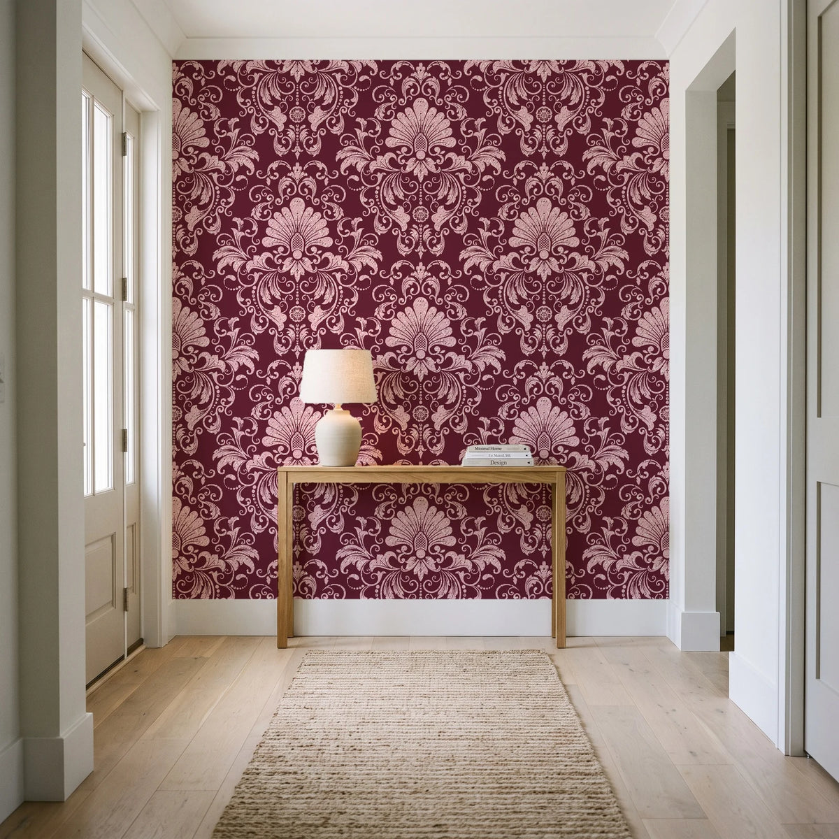 Blushed Whisper Oxblood distressed damask wallpaper behind a console table in a light entry hallway