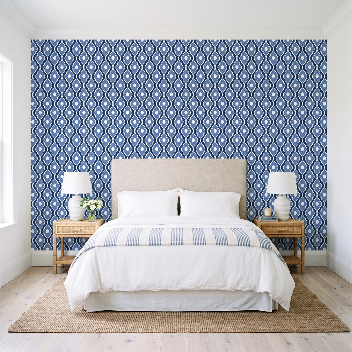 Butter Ogee Midnight ogee trellis wallpaper behind a queen bed in a bright coastal bedroom