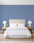 Butter Ogee Midnight ogee trellis wallpaper behind a queen bed in a bright coastal bedroom