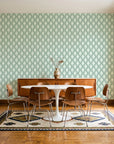 Butter Ogee Sage ogee trellis wallpaper in a mid-century dining room with a teak sideboard and tulip table