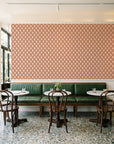 Butter Ogee Terracotta ogee trellis wallpaper above a green leather banquette in a sunlit neighborhood cafe