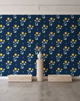 Buttercup Meadow Midnight floral sprig wallpaper behind a travertine pedestal and vase in a minimal boutique
