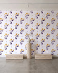 Buttercup Meadow Plum floral sprig wallpaper behind a travertine pedestal and vase in a minimal boutique