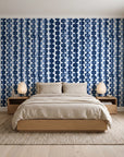 Cactus Lane Navy abstract stripe wallpaper behind a low platform bed in a serene Japandi bedroom