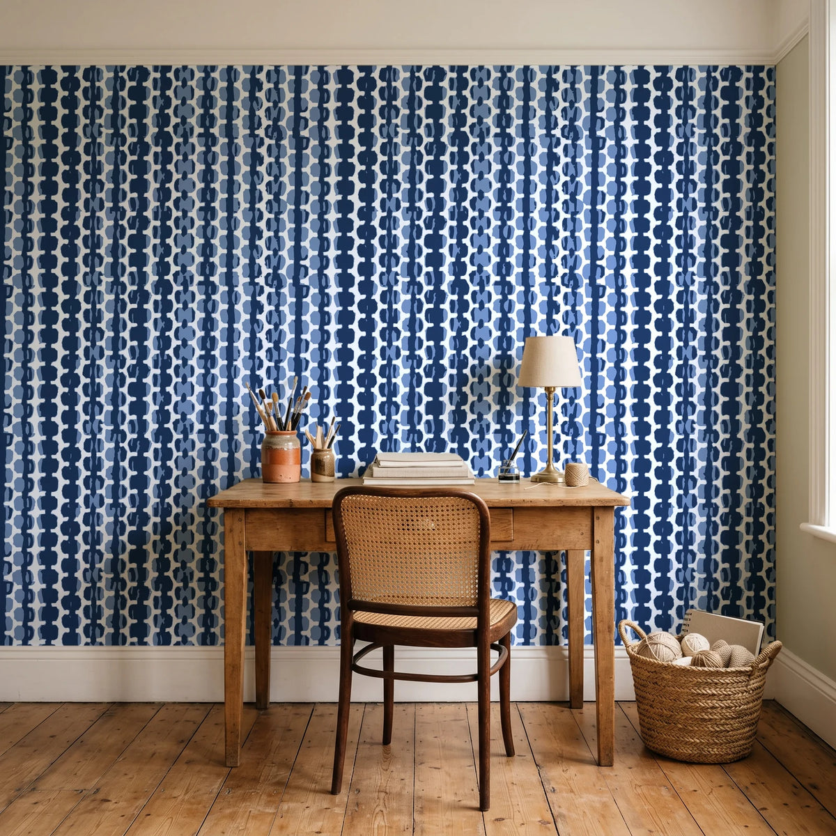 Cactus Lane Navy abstract stripe wallpaper behind a vintage writing desk in a cozy craft-room home office