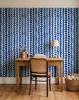 Cactus Lane Navy abstract stripe wallpaper behind a vintage writing desk in a cozy craft-room home office