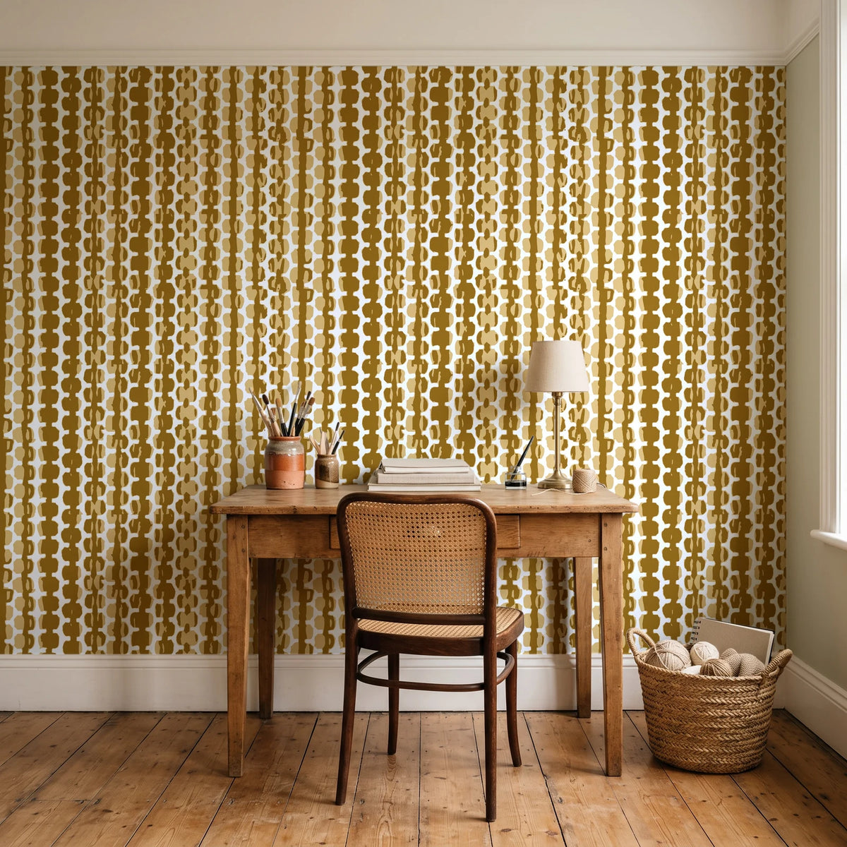 Cactus Lane Ochre abstract stripe wallpaper behind a vintage writing desk in a cozy craft-room home office