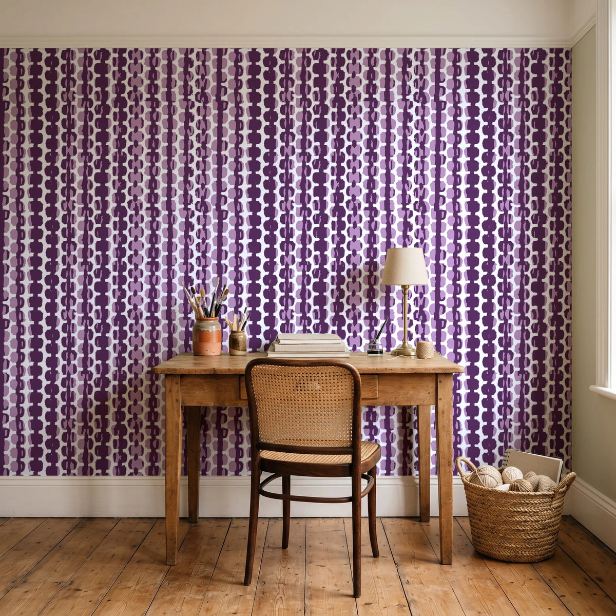 Cactus Lane Plum abstract stripe wallpaper behind a vintage writing desk in a cozy craft-room home office