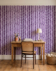 Cactus Lane Plum abstract stripe wallpaper behind a vintage writing desk in a cozy craft-room home office