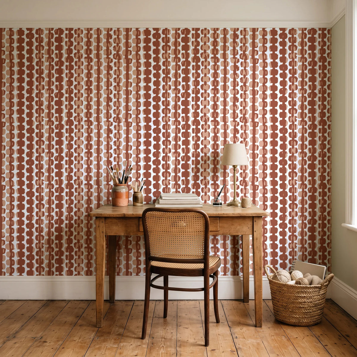 Cactus Lane Terracotta abstract stripe wallpaper behind a vintage writing desk in a cozy craft-room home office