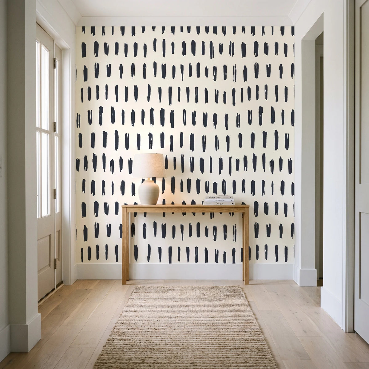Canvas Dash Charcoal minimalist dashes wallpaper behind a console table in a light entry hallway