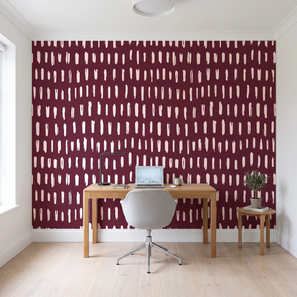 Canvas Dash Oxblood minimalist dashes wallpaper behind a modern oak desk in a bright home office