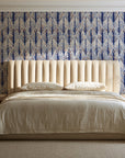 Canyon Ikat Bone geometric wallpaper behind a channel-tufted bed in a calm primary bedroom