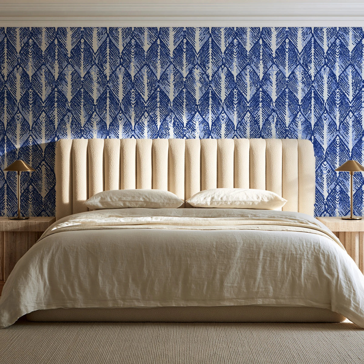 Canyon Ikat Indigo geometric wallpaper behind a channel-tufted bed in a calm primary bedroom