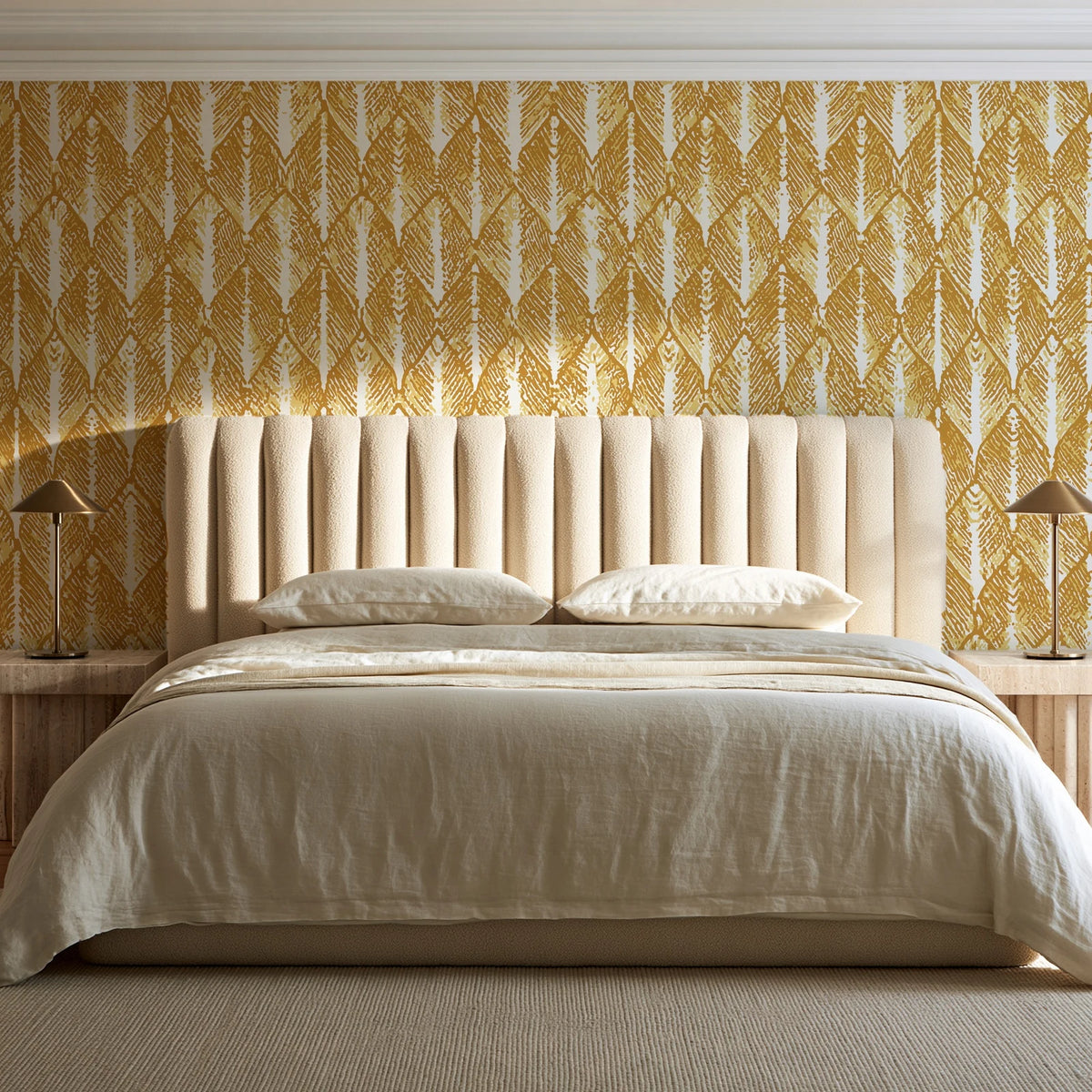 Canyon Ikat Ochre geometric wallpaper behind a channel-tufted bed in a calm primary bedroom