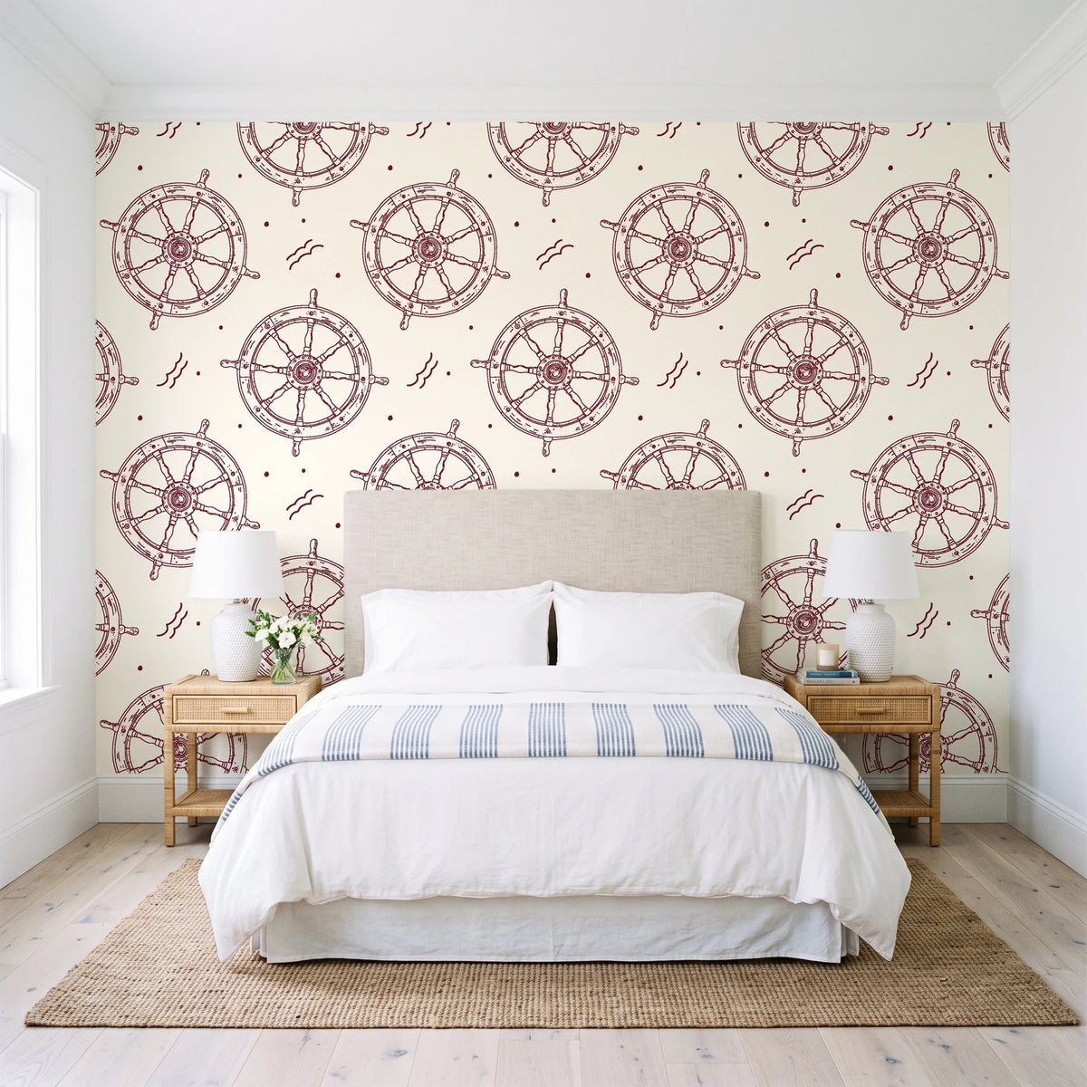 Captain's Wheel Burgundy nautical ship wheel wallpaper behind a queen bed in a bright coastal bedroom