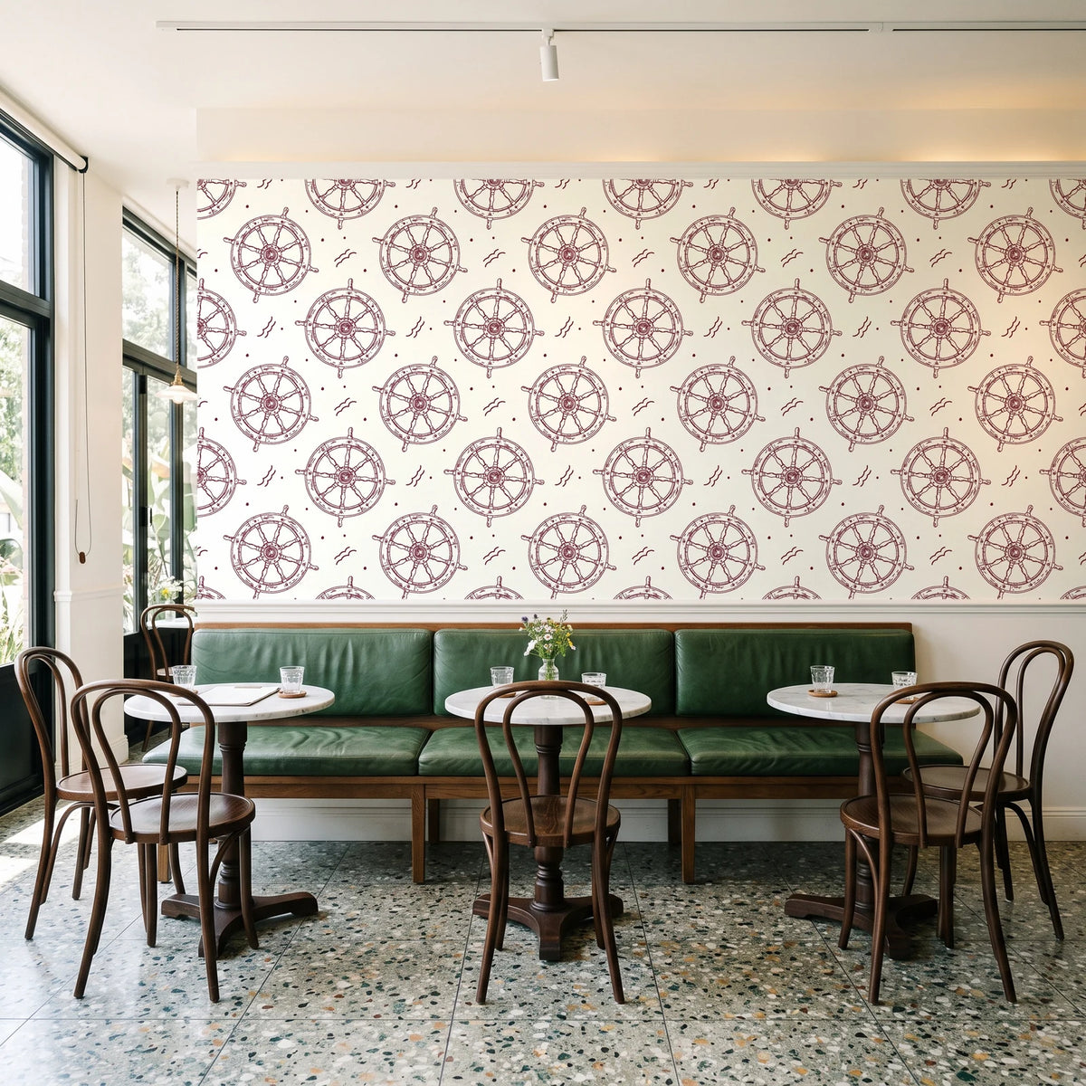 Captain's Wheel Burgundy nautical ship wheel wallpaper above a green leather banquette in a sunlit neighborhood cafe