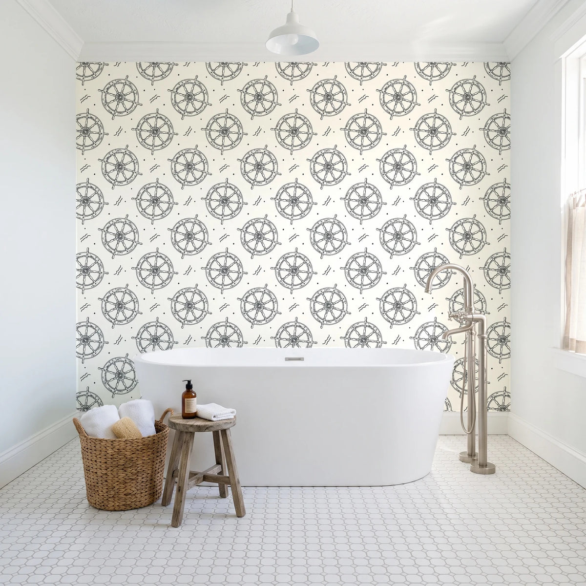 Captain's Wheel Charcoal nautical ship wheel wallpaper behind a freestanding tub in a bright coastal bathroom
