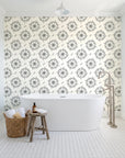 Captain's Wheel Charcoal nautical ship wheel wallpaper behind a freestanding tub in a bright coastal bathroom