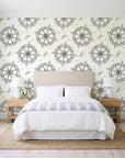 Captain's Wheel Charcoal nautical ship wheel wallpaper behind a queen bed in a bright coastal bedroom