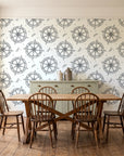 Captain's Wheel Charcoal nautical ship wheel wallpaper in a farmhouse dining room with a sage sideboard and rustic trestle table
