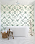 Captain's Wheel Evergreen nautical ship wheel wallpaper behind a freestanding tub in a bright coastal bathroom