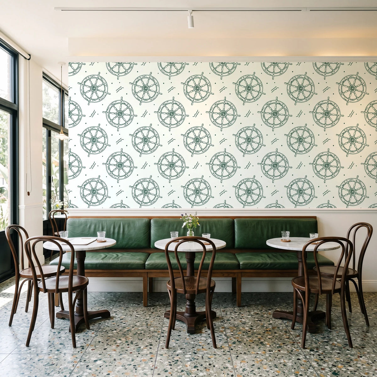 Captain's Wheel Evergreen nautical ship wheel wallpaper above a green leather banquette in a sunlit neighborhood cafe