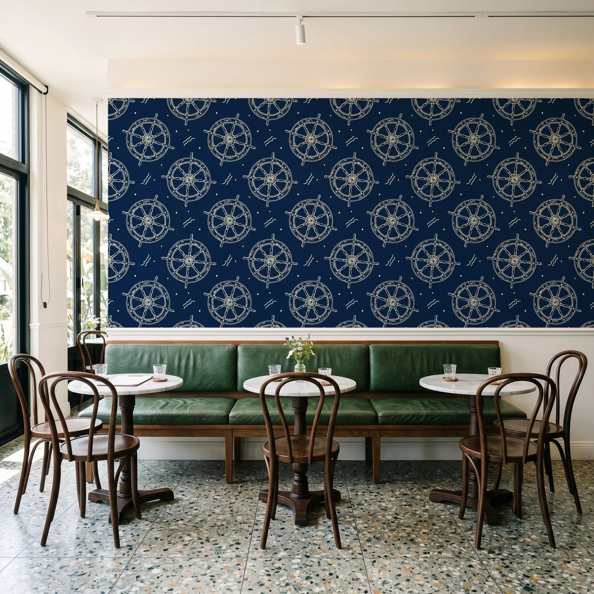 Captain's Wheel Midnight nautical ship wheel wallpaper above a green leather banquette in a sunlit neighborhood cafe