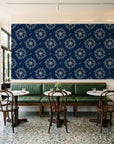Captain's Wheel Midnight nautical ship wheel wallpaper above a green leather banquette in a sunlit neighborhood cafe