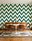 Caramel Drip Emerald chevron wallpaper in a mid-century dining room with a teak sideboard and tulip table