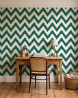 Caramel Drip Emerald chevron wallpaper behind a vintage writing desk in a cozy craft-room home office