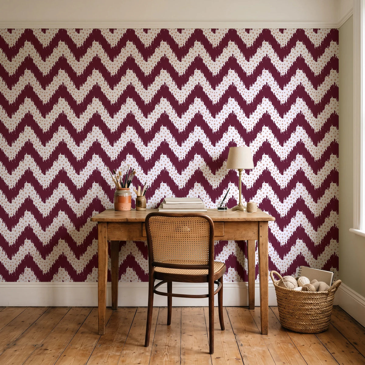 Caramel Drip Oxblood chevron wallpaper behind a vintage writing desk in a cozy craft-room home office