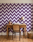 Caramel Drip Plum chevron wallpaper behind a vintage writing desk in a cozy craft-room home office