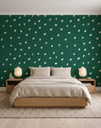 Caramel Haze Emerald brushstroke dot wallpaper behind a low platform bed in a serene Japandi bedroom
