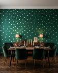 Caramel Haze Emerald brushstroke dot wallpaper in a dark moody dining room with a candlelit table