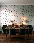 Caramel Haze Ivory brushstroke dot wallpaper in a dark moody dining room with a candlelit table