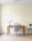 Caramel Haze Ivory brushstroke dot wallpaper behind a modern oak desk in a bright home office