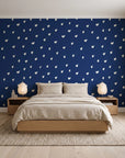 Caramel Haze Navy brushstroke dot wallpaper behind a low platform bed in a serene Japandi bedroom